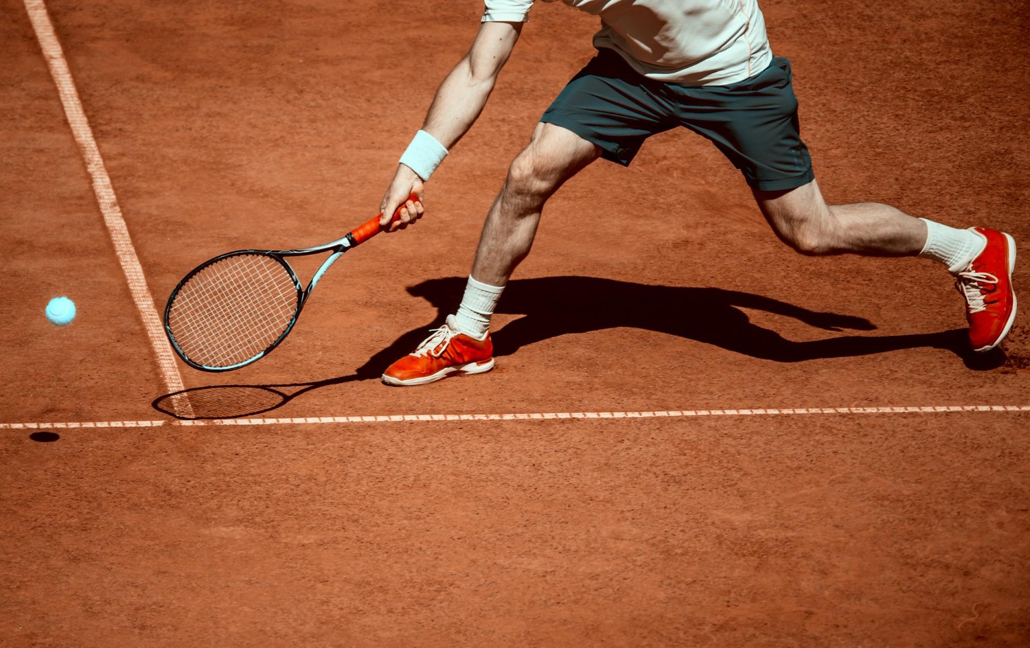 Tenista golpeando la pelota en arcilla