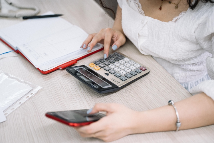 Persona revisando un presupuesto mensual para controlar sus gastos fijos y variables.