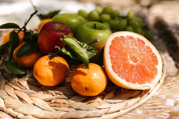 Toronja fresca junto a otras frutas saludables recomendadas para favorecer la salud del hígado y mantener niveles adecuados de triglicéridos.