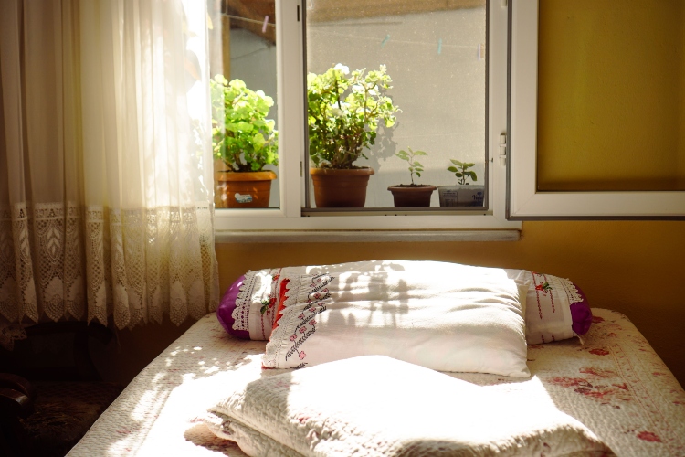 Dormitorio ventilado con la cama sin tender mientras entra luz natural para reducir la humedad acumulada durante la noche.