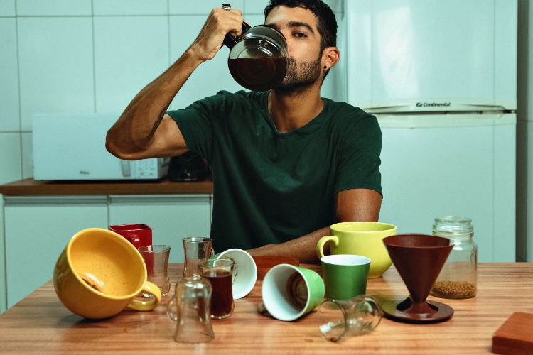 Taza de café sobre un reloj que muestra las dos de la tarde, ilustrando el mejor momento para tomar el último café del día y proteger el descanso.